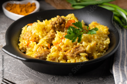 Traditional azian pilaf served in plate on gray background
