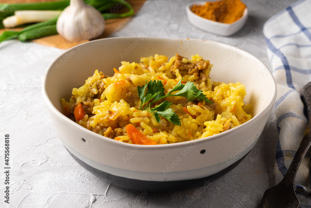 Traditional azian pilaf served in plate on gray background Traditional azian pilaf served in plate on gray background