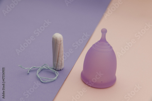Menstrual cup and tampons on a colorful background close-up. Concept of women's hygiene