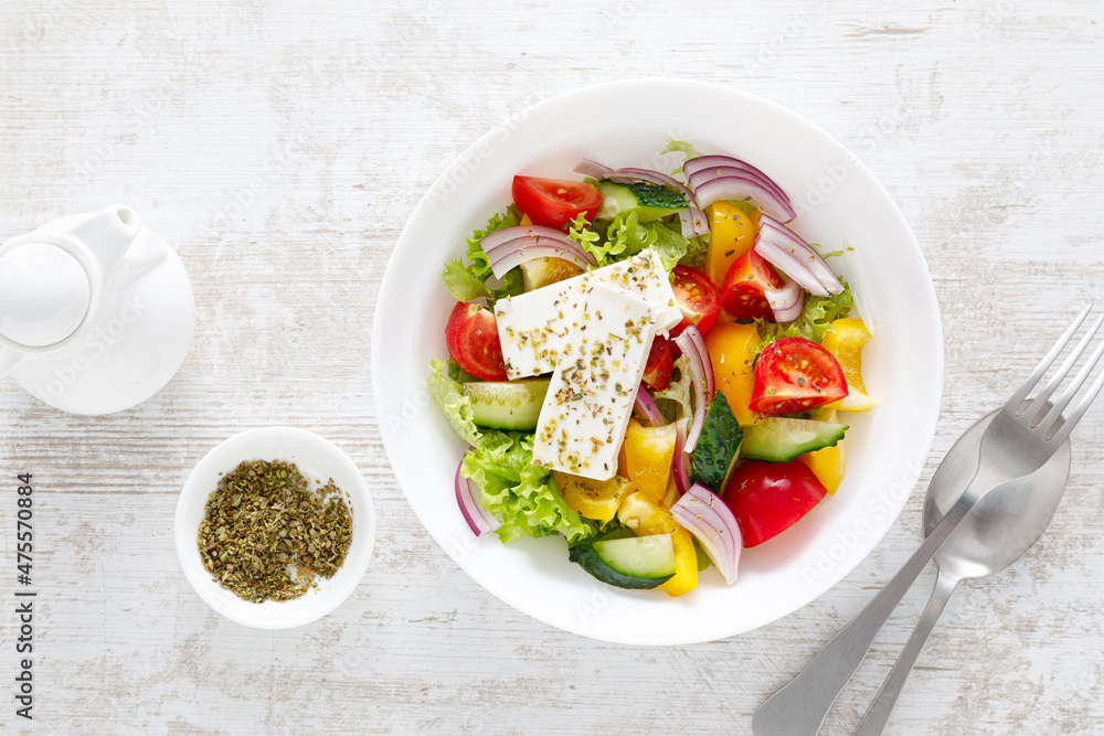 Fresh summer vegetable salad with lettuce, tomato, cucumber, bell pepper, onion and feta cheese, dressed with olive oil. Top view Fresh summer vegetable salad with lettuce, tomato, cucumber, bell pepper, onion and feta cheese, dressed with olive oil. Top view