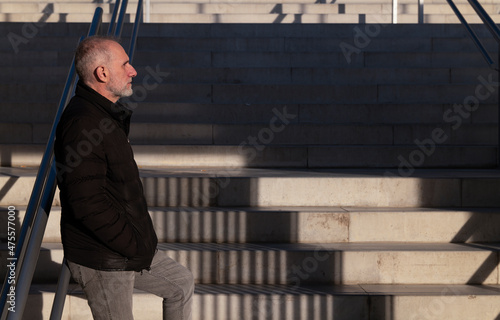 Adult man in winter cloth on stairway. Madrid, Spain