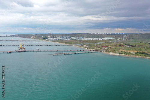 The water area of the sea cargo port. Berth with self-leveling trestles. Shooting from a drone.
