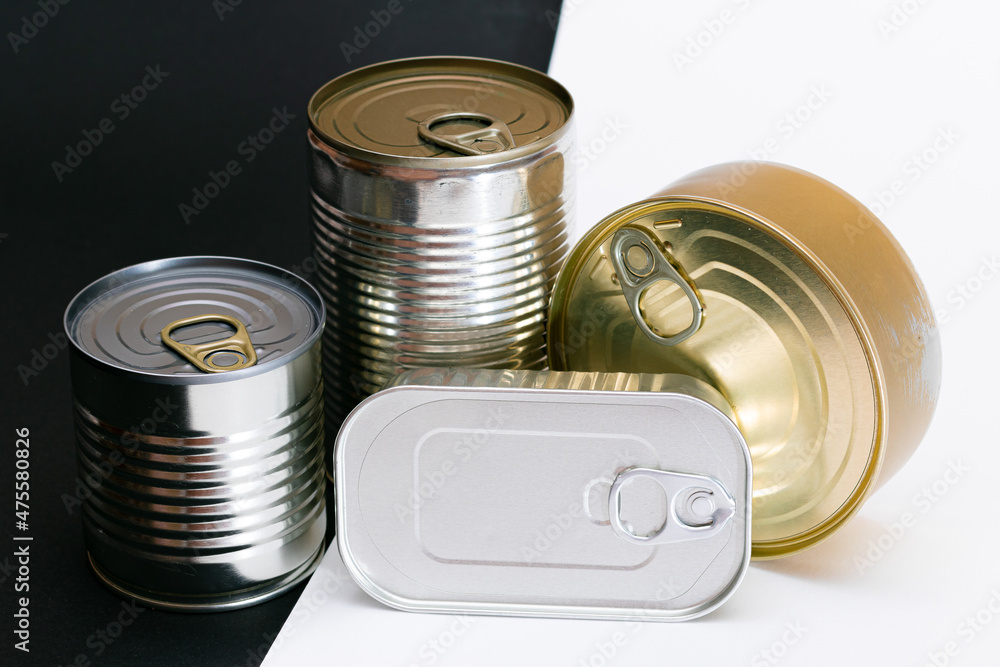 A Group of Stacked Tin Cans with Blank Edges on Split Black and White Background. Canned Food. Different Aluminum Cans for Safe and Long Term Storage of Food. Steel Sealed Food Storage Containers A Group of Stacked Tin Cans with Blank Edges on Split Black and White Background. Canned Food. Different Aluminum Cans for Safe and Long Term Storage of Food. Steel Sealed Food Storage Containers