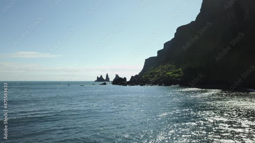 Ocean below large green rock formations aerial Ocean below large green rock formations aerial