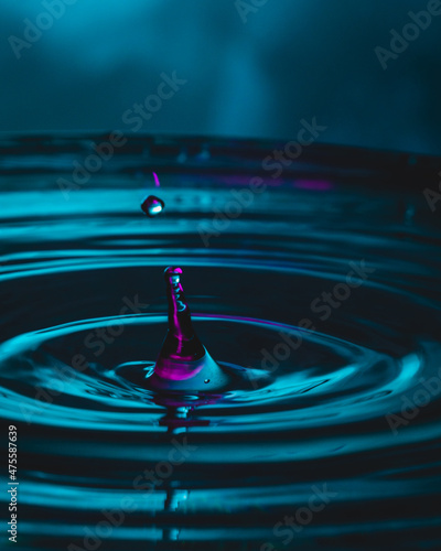 Purple water drops on water surface.