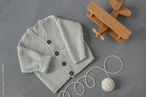Quadro su tela knitted children's cardigan with a ball of natural yarn on a gray background wit