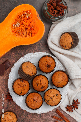 Freshly baked homemade pumpkin muffins with chocolate and spices (cinnamon, star anise, cardamom). Healthy homemade cakes for breakfast. Selective focus, top view
