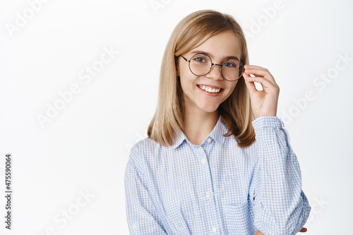 Cute smiling little girl, teen child wearing glasses for sight, looking happy, standing over white background
