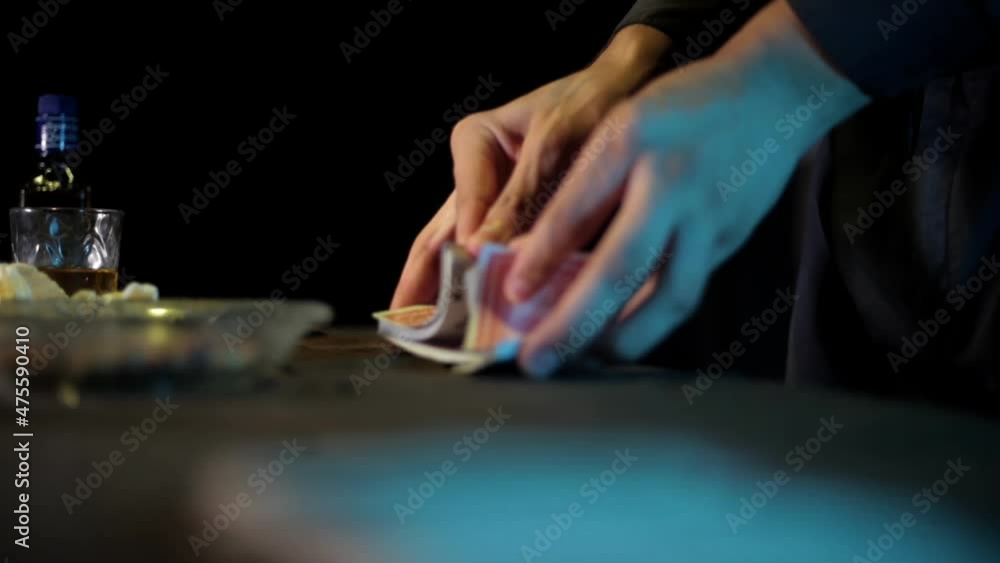 Close-up shot of a magician shuffling cards on the table in dark lighting, high-resolution footage.
Close-up shot of a magician shuffling cards on the table in dark lighting, high-resolution footage.