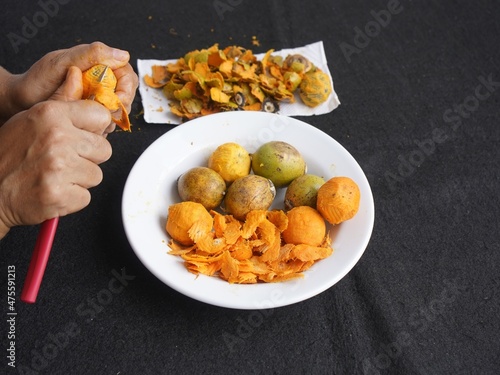 Woman peeling Tucuma fruits, Astrocaryum aculeatum, Arecaceae family. Amazon, Brazi photo