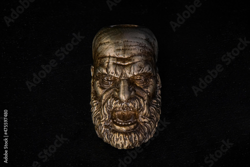 The figure of a bearded screaming man made of bronze