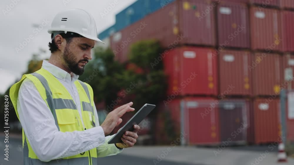Man standing at cargor harbor with tablet in hands Man standing at cargor harbor with tablet in hands