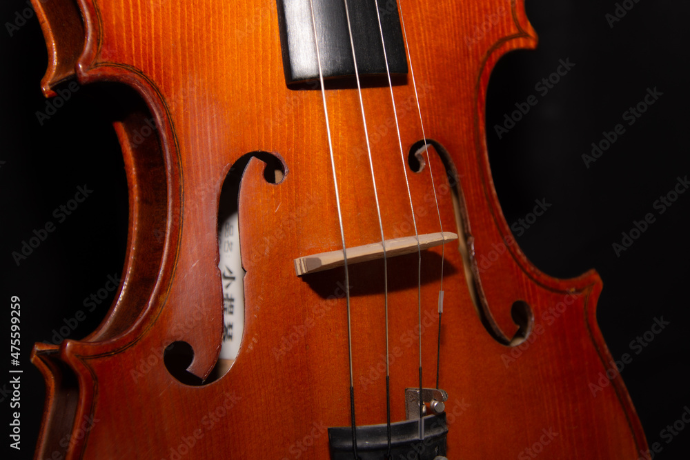 Details of a pretty violin that waits alone in the dark to play music Details of a pretty violin that waits alone in the dark to play music