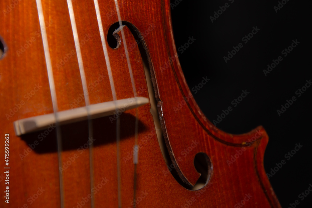 Details of a pretty violin that waits alone in the dark to play music Details of a pretty violin that waits alone in the dark to play music
