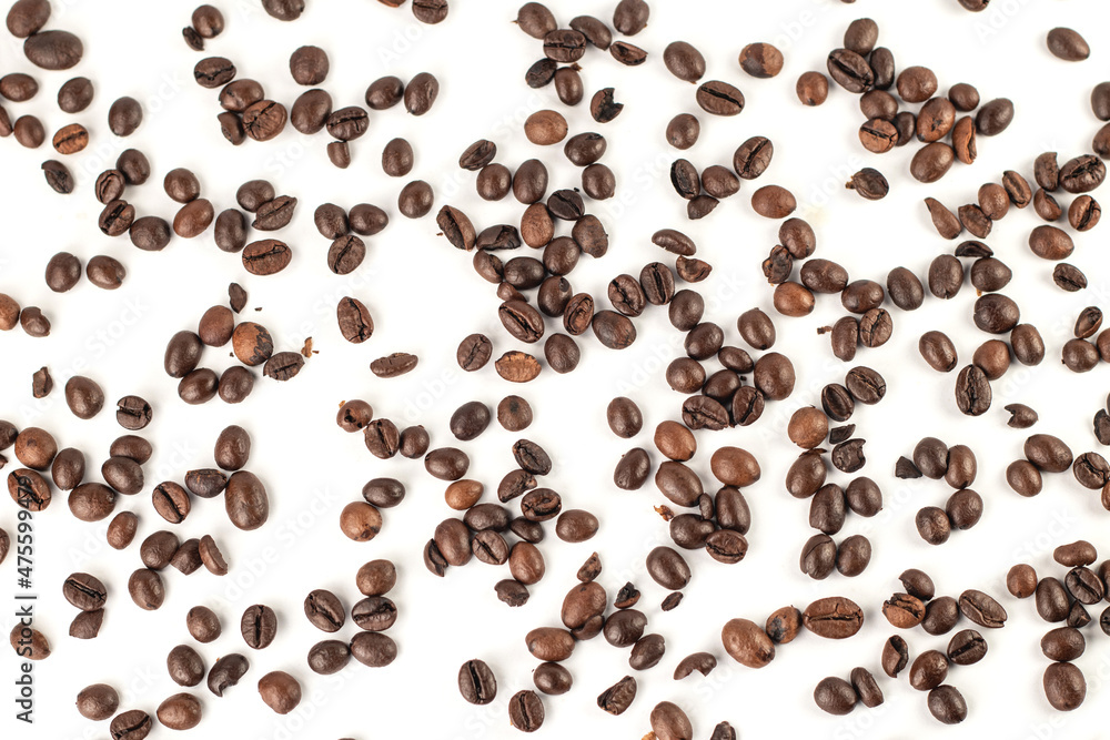 Obraz premium Top view of coffee beans scattered on white background.