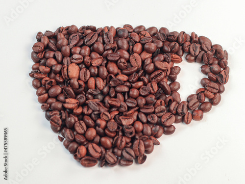 Cup shape made of coffee beans on white background
