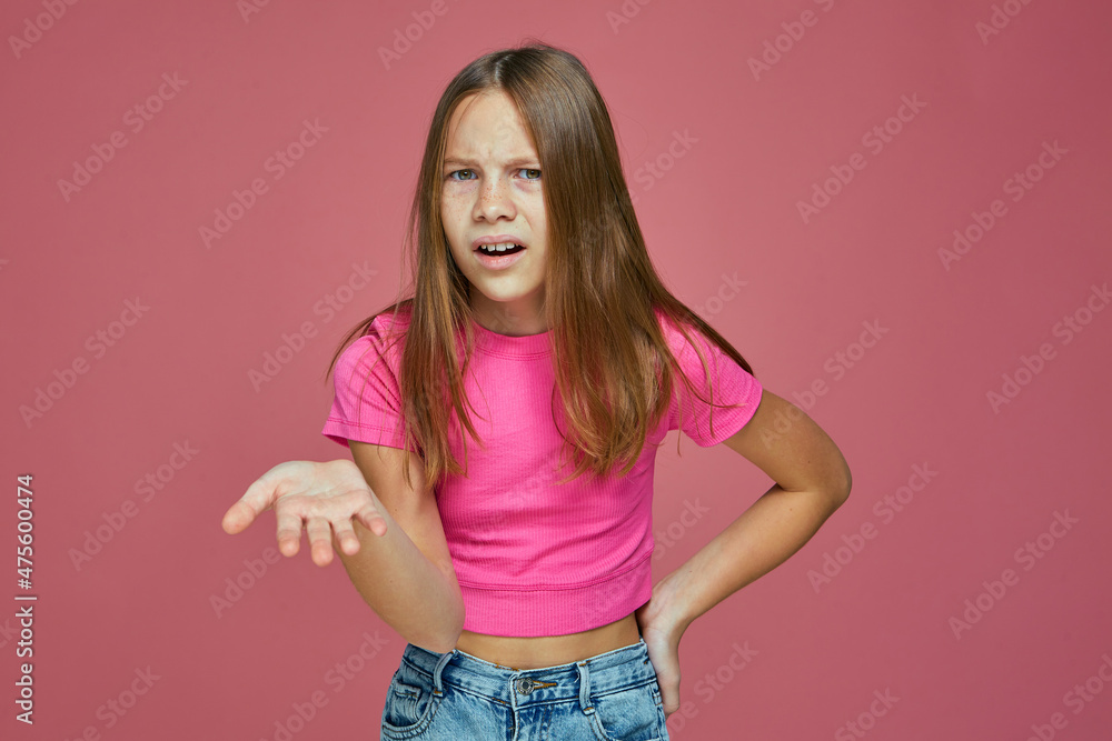 Displeased irritated teen girl asking what on pink background. Misunderstanding, confrontation, children disassembly Displeased irritated teen girl asking what on pink background. Misunderstanding, confrontation, children disassembly