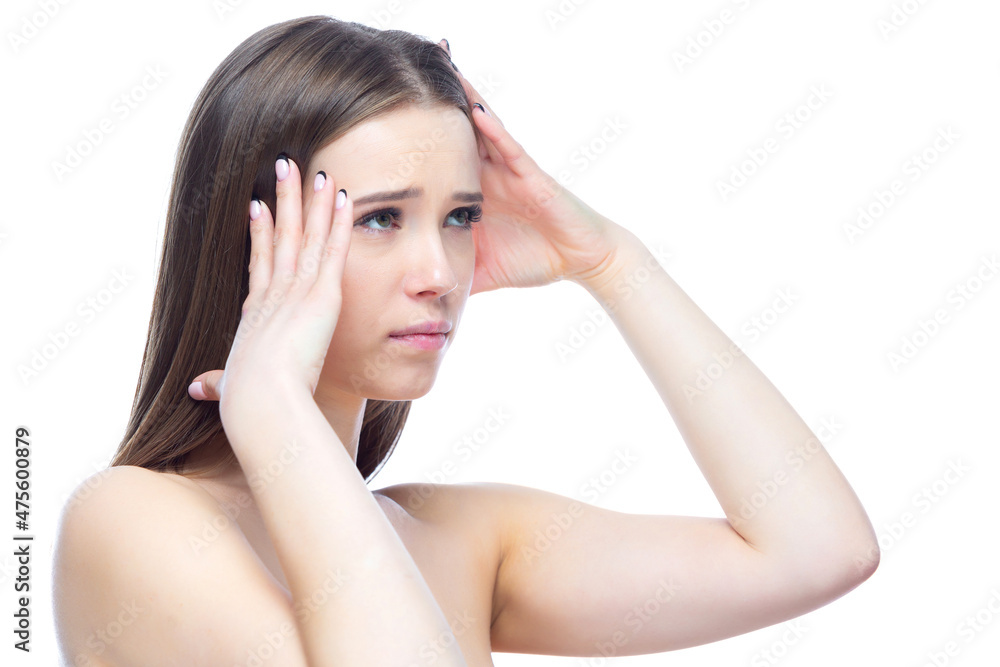 Photo of a young beautiful girl experiencing an attack of severe headache, standing with her hands near her head on a white background Photo of a young beautiful girl experiencing an attack of severe headache, standing with her hands near her head on a white background