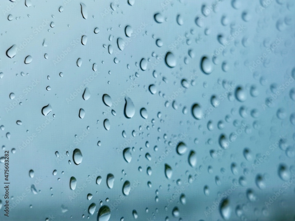 Rainwater drops on blue glass