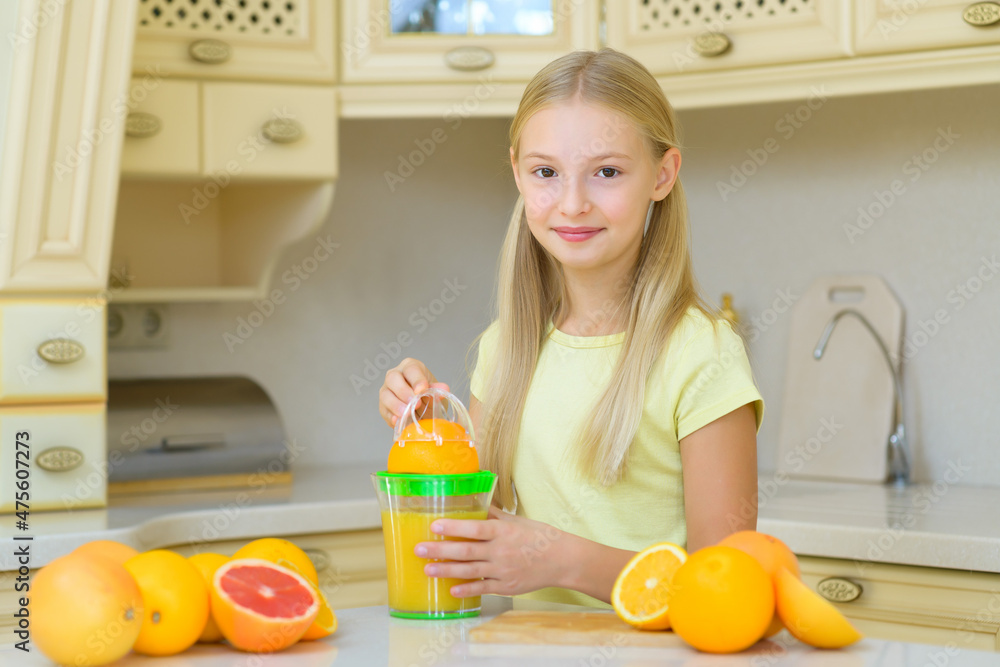 Teenage child makes orange and grapefruit juice from fresh produce Teenage child makes orange and grapefruit juice from fresh produce