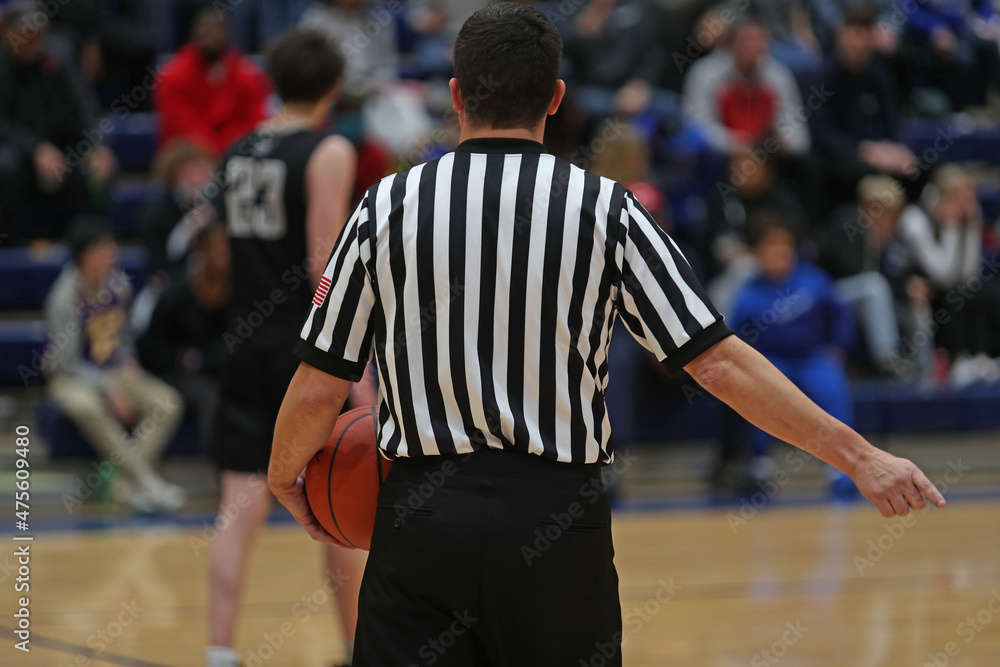 A basketball official points to where the ball is to be put into play