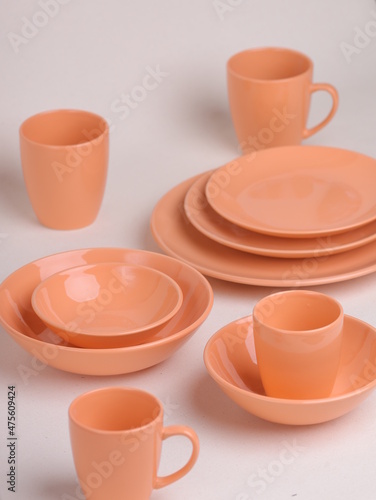 set of orange ceramic dishes on a light background