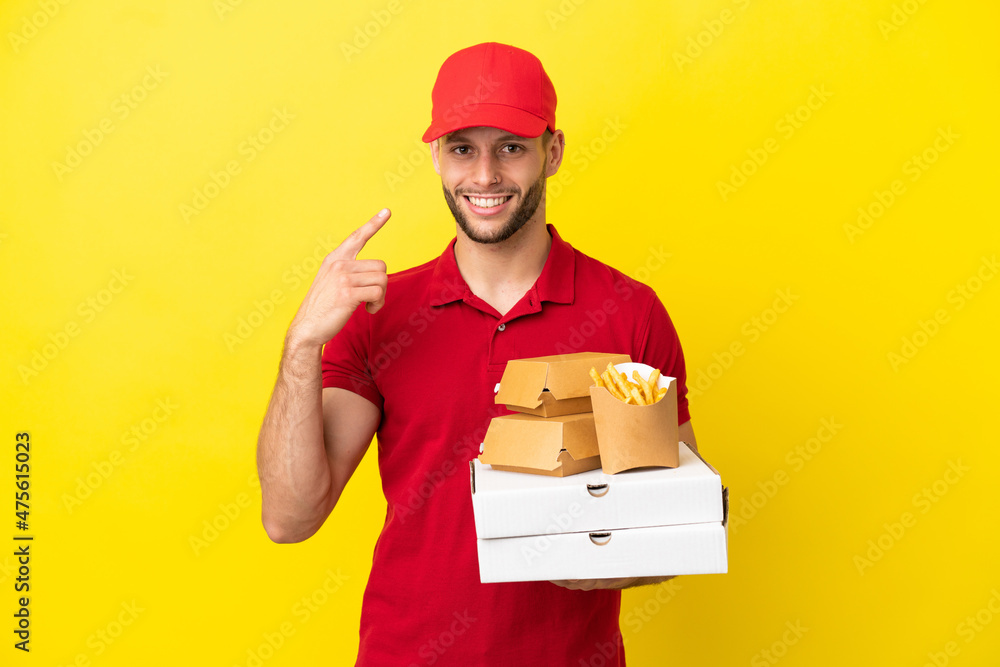pizza delivery man picking up pizza boxes and burgers over isolated background giving a thumbs up gesture pizza delivery man picking up pizza boxes and burgers over isolated background giving a thumbs up gesture