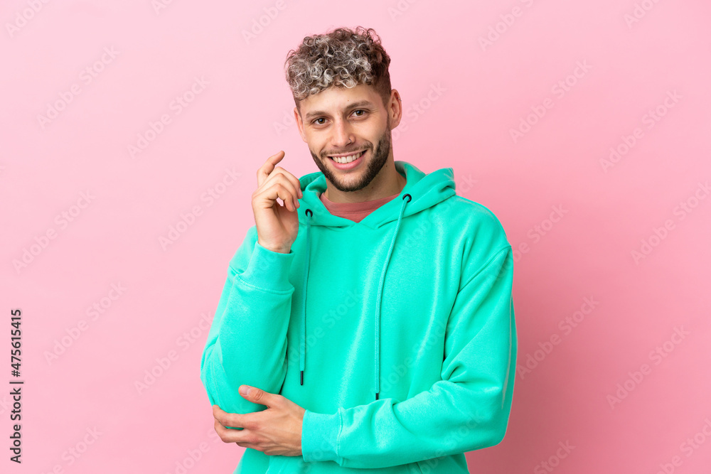 Young handsome caucasian man isolated on pink background laughing Young handsome caucasian man isolated on pink background laughing