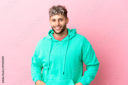 Young handsome caucasian man isolated on pink background laughing © luismolinero