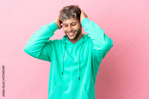 Young handsome caucasian man isolated on pink background laughing