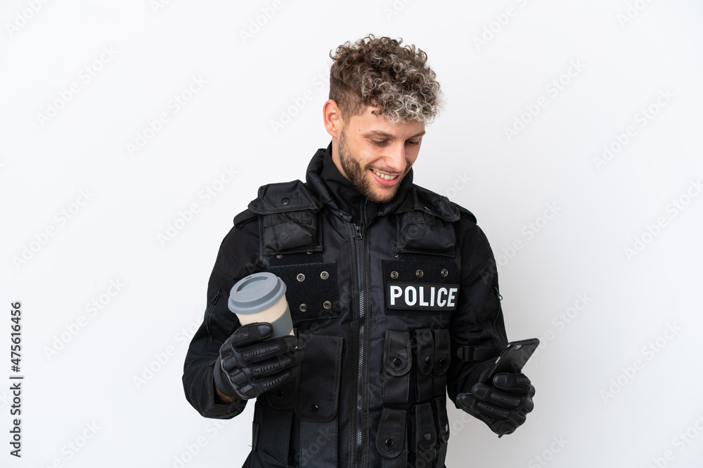 SWAT caucasian man isolated on white background holding coffee to take away and a mobile SWAT caucasian man isolated on white background holding coffee to take away and a mobile