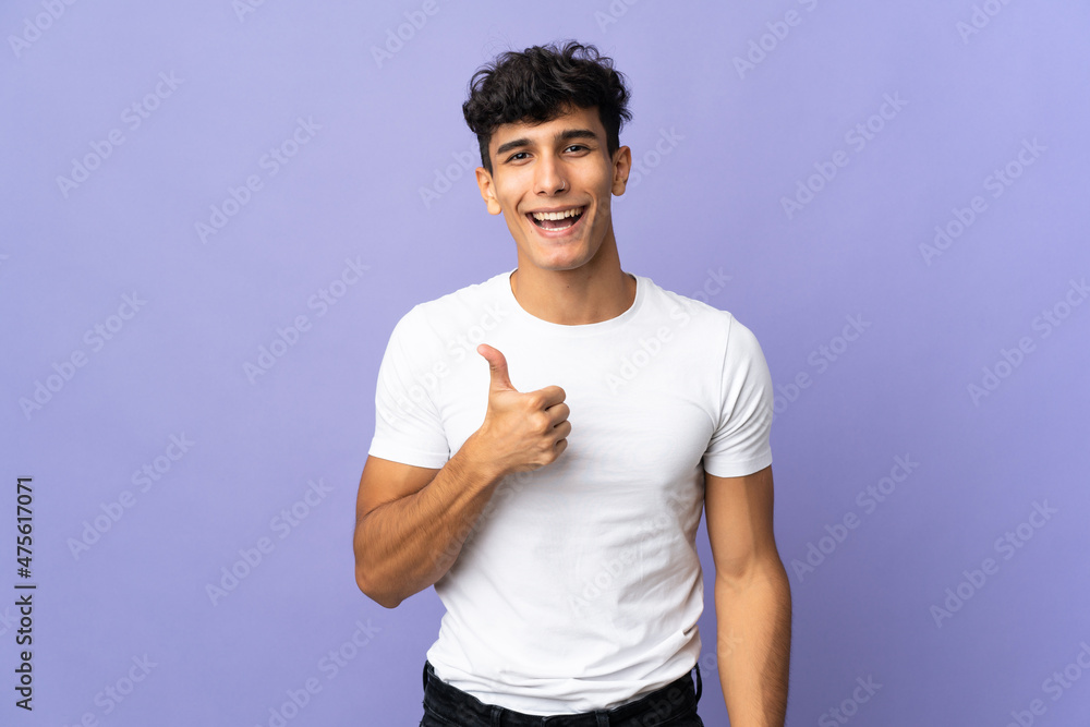 Young Argentinian man isolated on background giving a thumbs up gesture Young Argentinian man isolated on background giving a thumbs up gesture