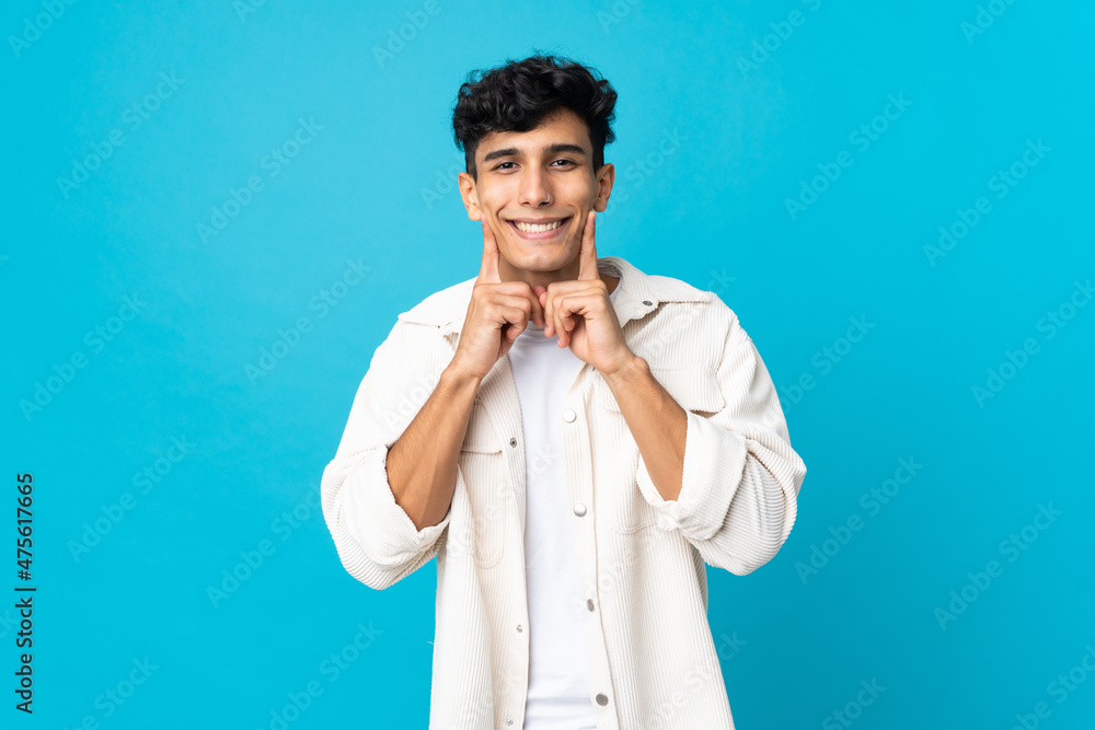 Young Argentinian man isolated on background smiling with a happy and pleasant expression