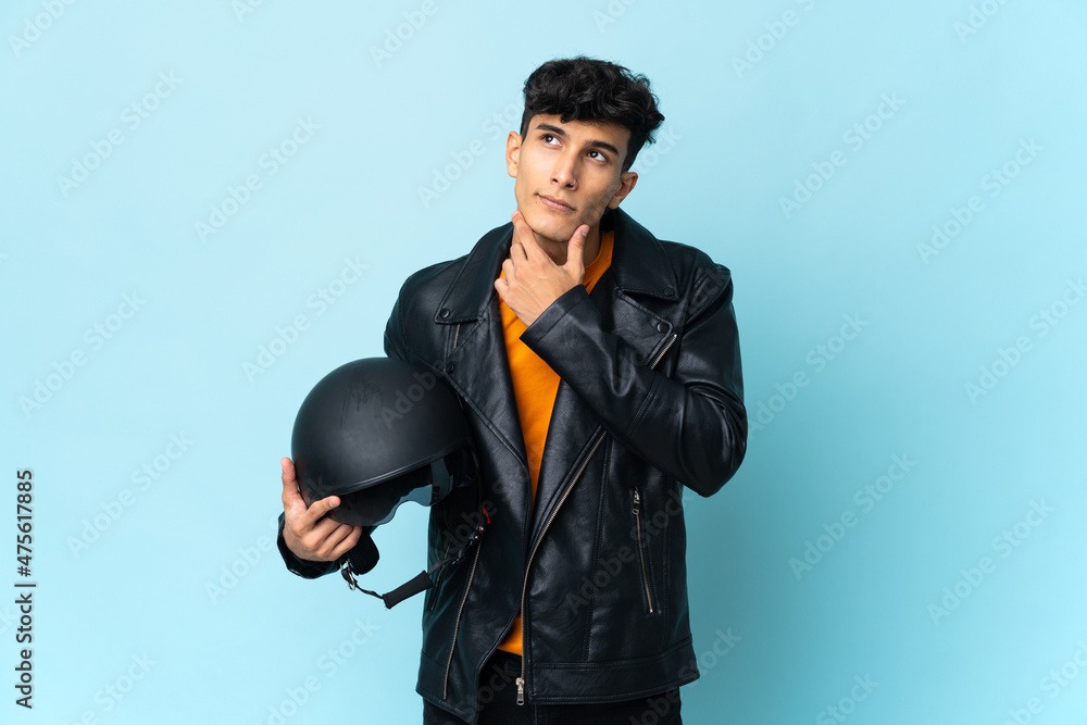 Argentinian man with a motorcycle helmet having doubts Argentinian man with a motorcycle helmet having doubts