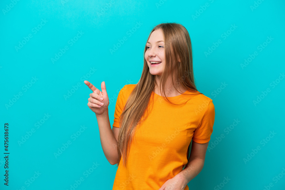 Fototapeta premium Young Russian woman isolated on blue background pointing finger to the side and presenting a product