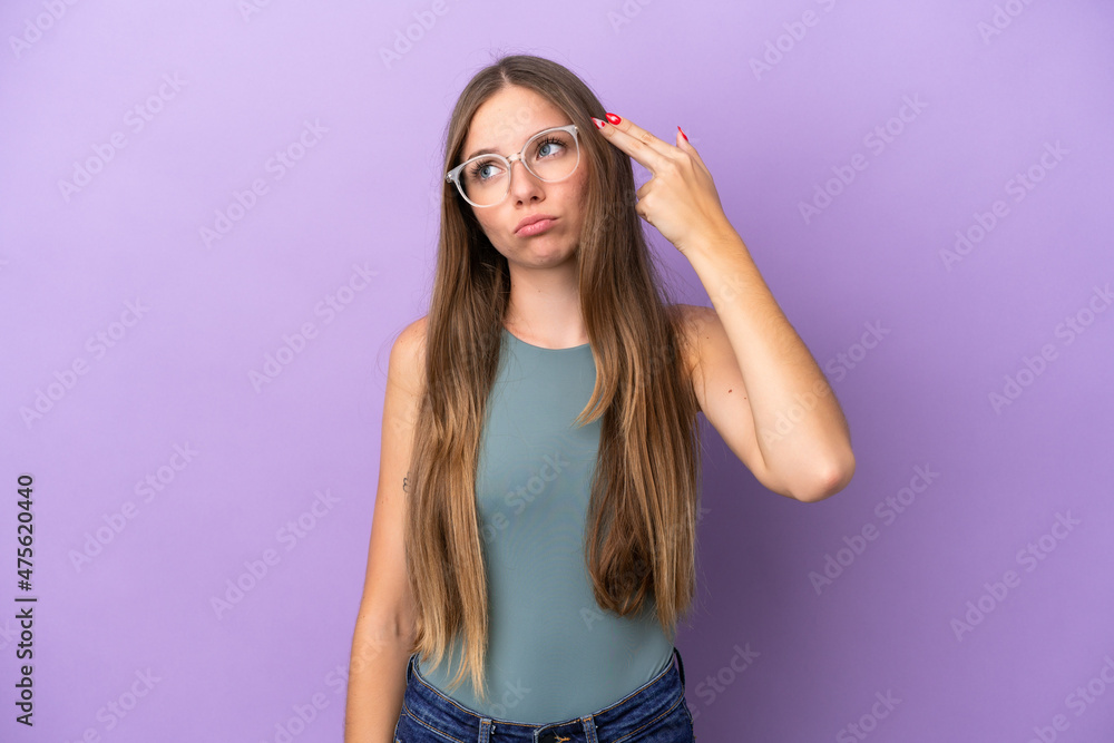 Young Lithuanian woman isolated on purple background with problems making suicide gesture Young Lithuanian woman isolated on purple background with problems making suicide gesture