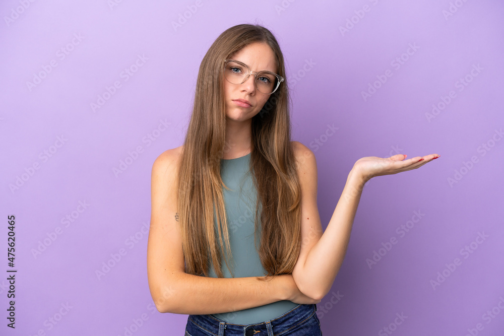 Young Lithuanian woman isolated on purple background having doubts Young Lithuanian woman isolated on purple background having doubts