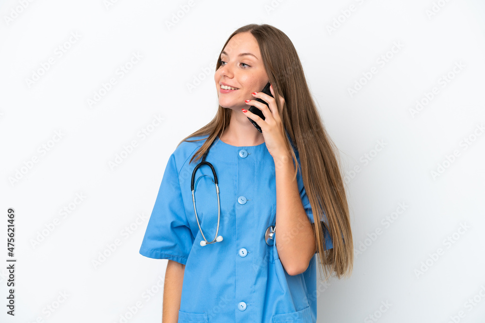 Young surgeon doctor Lithuanian woman isolated on white background keeping a conversation with the mobile phone with someone