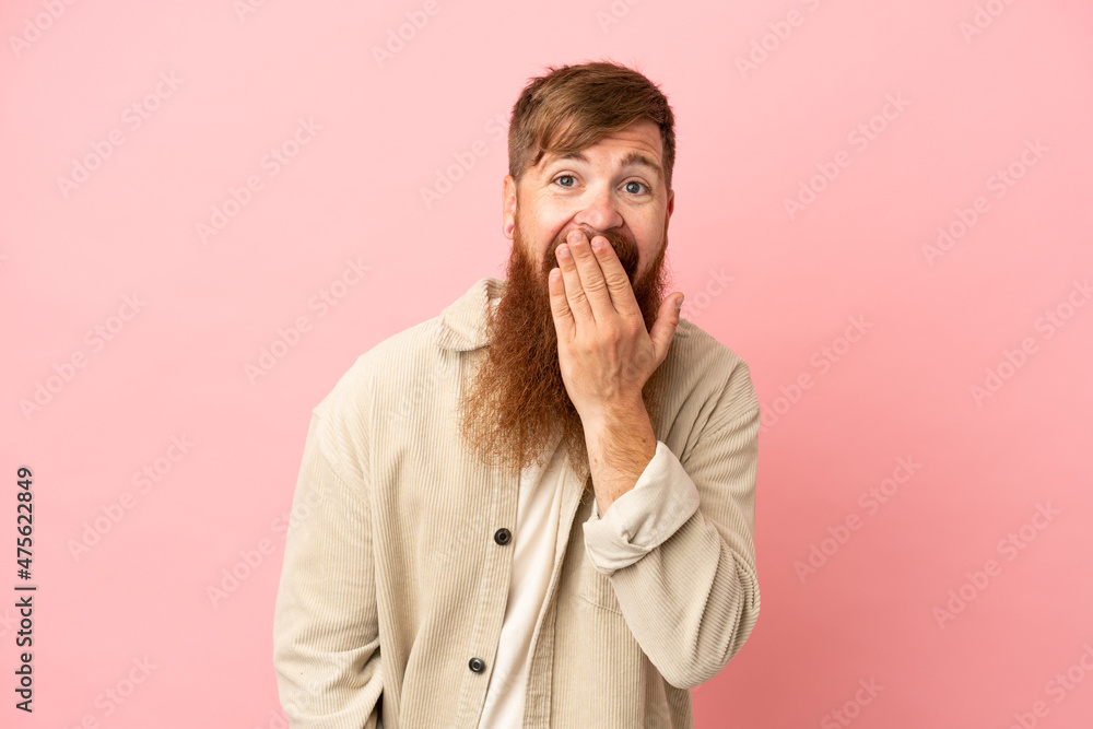 Young reddish caucasian man isolated on pink background happy and smiling covering mouth with hand Young reddish caucasian man isolated on pink background happy and smiling covering mouth with hand