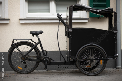 carrier cycle parking on street next to house waiting to get packed with heavy loads to be carried by cycler within city environmentally friendly photo