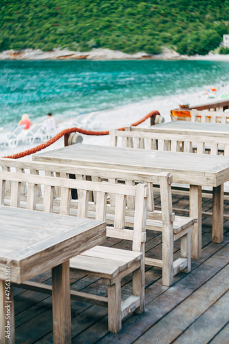Long wooden benches and tables in a restaurant on the seaside