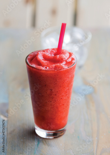 Iced strawberry slushy smoothie in a tall glass photo