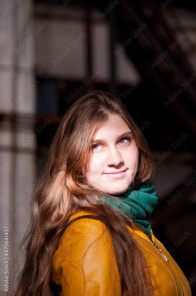 Portrait of a beautiful girl with long hair in a yellow jacket and a green scarf Portrait of a beautiful girl with long hair in a yellow jacket and a green scarf