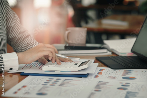 businesswoman working at office with document on her desk, doing planning analyzing the financial report, business plan investment, finance analysis concept.Using calculator and tablet.