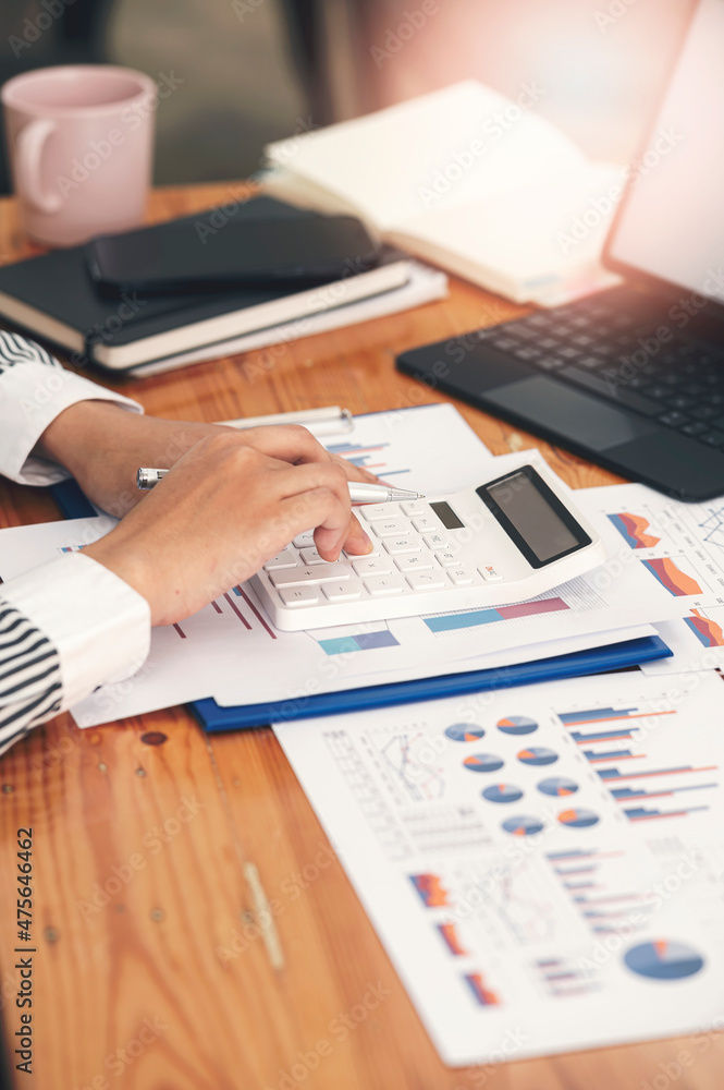 businesswoman working at office with document on her desk, doing planning analyzing the financial report, business plan investment, finance analysis concept.Using calculator and tablet.