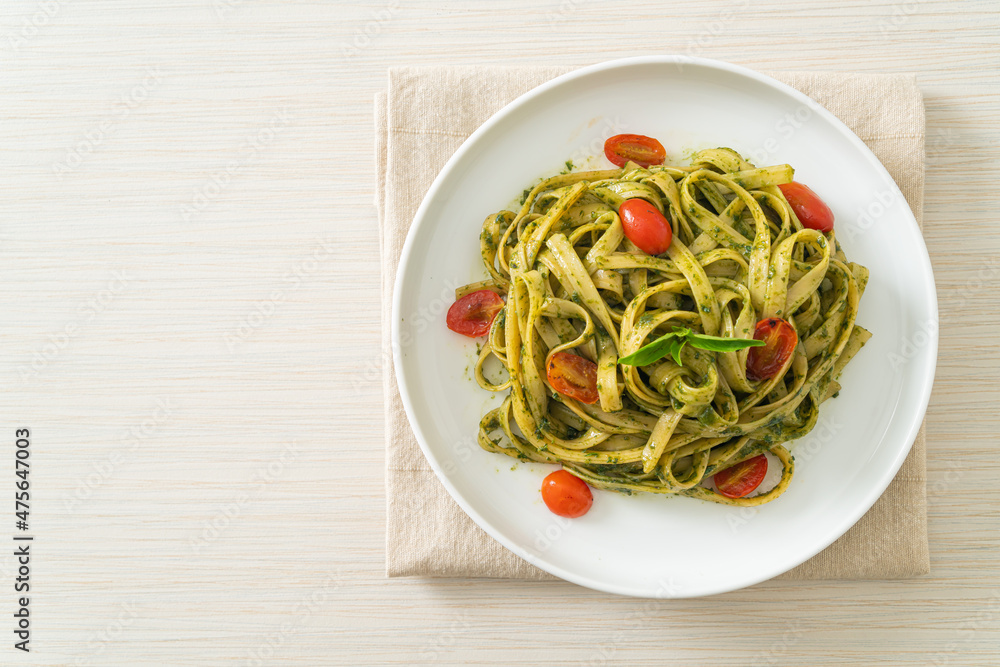 fettuccine spaghetti pasta with pesto sauce and tomatoes