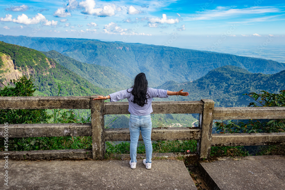 Naklejka premium young girl enjoying the mountain range with bright blue sky at afternoon from flat angle