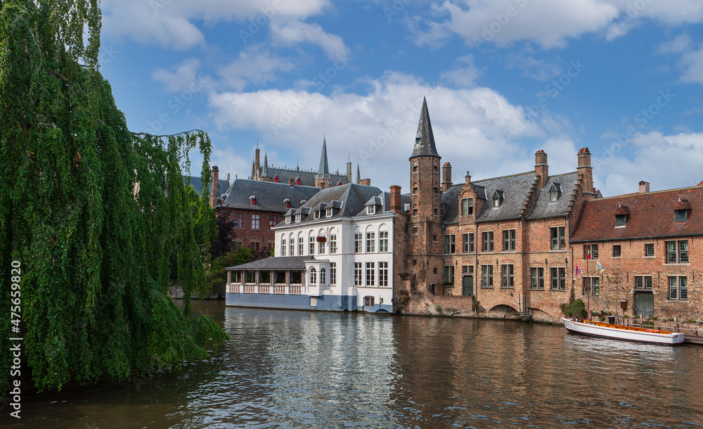 City view with historical houses, church, tower and famous canal in Bruges, Belgium.