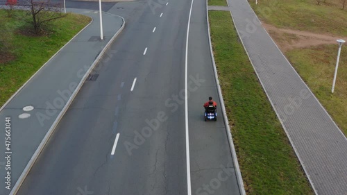 Wallpaper Mural Aerial view of a caucasian man who is living with a disability with amputated both legs and both arms driving alone on a modern electric wheelchair along the empty road Torontodigital.ca