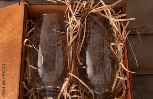 two champagne glasses in a wooden gift box with shavings for softness. holiday concept